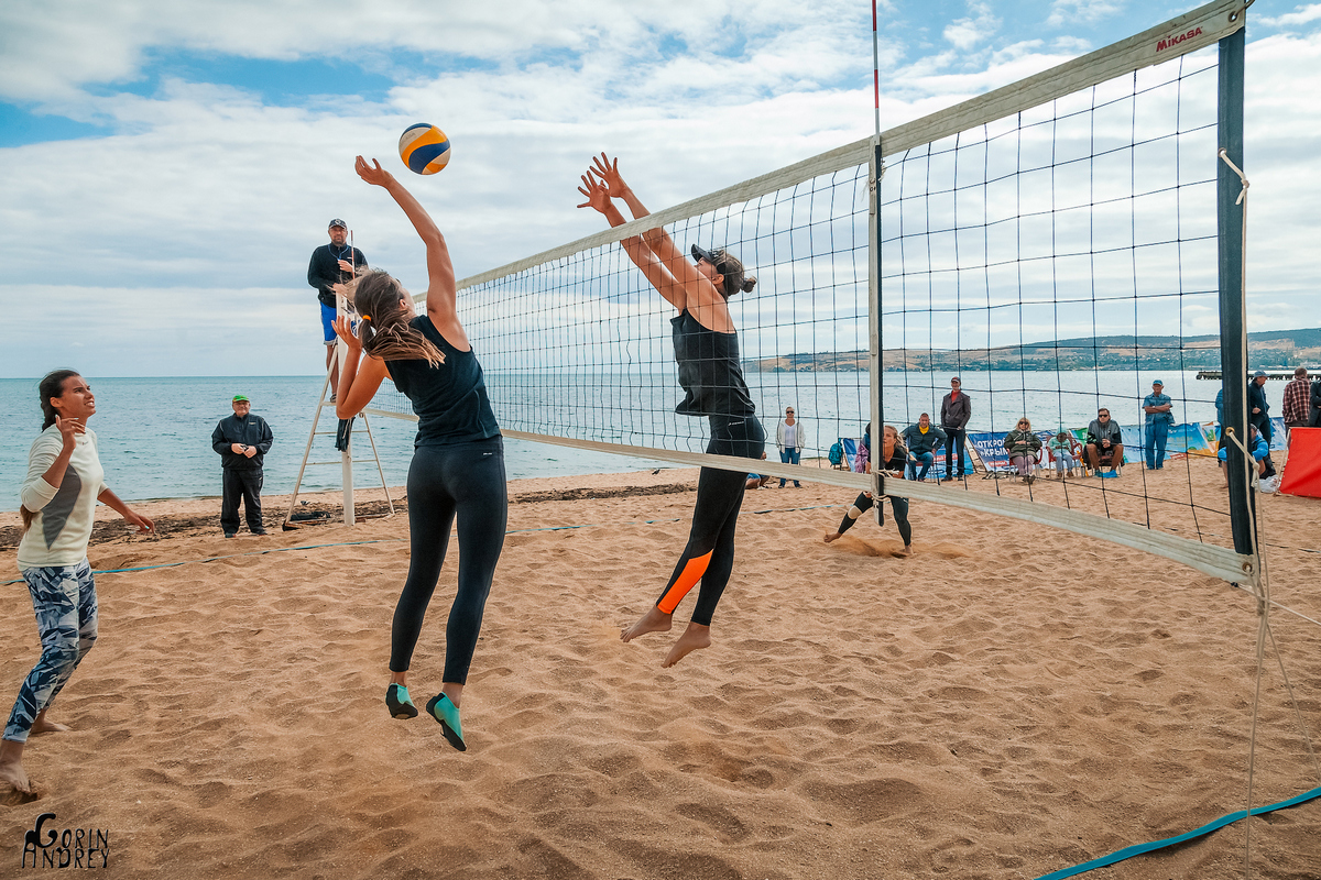 Женские команды играют в пляжный волейбол